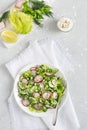 Fresh salad of cucumbers, radishes, green peas and herbs in white bowl. Top view. Vertical orientation Royalty Free Stock Photo