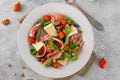 Fresh salad with figs, prosciutto or jamon, brie cheese, tomatoes and walnuts on a concrete background Royalty Free Stock Photo