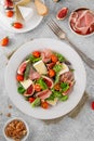 Fresh salad with figs, prosciutto or jamon, brie cheese, tomatoes and walnuts on a concrete background Royalty Free Stock Photo
