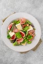 Fresh salad with figs, prosciutto or jamon, brie cheese and walnuts on a concrete background Royalty Free Stock Photo