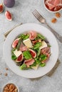 Fresh salad with figs, prosciutto or jamon, brie cheese and walnuts on a concrete background Royalty Free Stock Photo