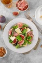 Fresh salad with figs, prosciutto or jamon, brie cheese and walnuts on a concrete background Royalty Free Stock Photo