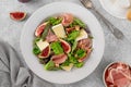 Fresh salad with figs, prosciutto or jamon, brie cheese and walnuts on a concrete background Royalty Free Stock Photo