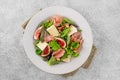 Fresh salad with figs, prosciutto or jamon, brie cheese and walnuts on a concrete background Royalty Free Stock Photo