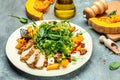 Fresh salad with grilled chicken fillet, feta cheese, caramelized pumpkin, superfood keto diet concept. Healthy, clean eating, top Royalty Free Stock Photo