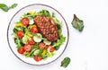 Fresh salad with grilled duck breast with red tomato, cucumber, paprika and chard, frisse, mizuna and arugula leaves on white Royalty Free Stock Photo