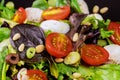 Fresh salad with lettuce, cherry tomatoes, mozzarella cheese and olives in a healthy food