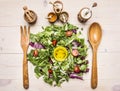 Fresh salad mix with butter and spices, wooden spoon and fork for the salad. Superfoods and health detox diet food concept on w