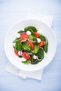 Fresh salad with mozzarella cheese, tomato, spinach and purple onion on blue wooden background top view Royalty Free Stock Photo