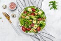 Fresh salad with mussels, quail, egg, conjugate, lime, spinach, lettuce, cherry tomatoes and microgreen on a light background.