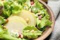 Fresh salad with pear slices in wooden bowl, closeup Royalty Free Stock Photo