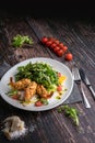 Fresh salad plate with shrimp, tomato, arugula, orange on wooden dark background close up. Healthy food concept in rustic style Royalty Free Stock Photo