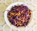 Fresh salad - red cabbage, carrots and parsley on a white plate and decorated cover - top view