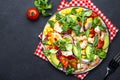 Fresh salad with shrimps, sweet corn, avocado, red tomatoes, lamb lettuce and onion on black table background. Top view Royalty Free Stock Photo