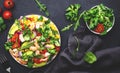 Fresh salad with shrimps, sweet corn, avocado, red tomatoes, lamb lettuce and onion on black table background. Top view Royalty Free Stock Photo