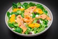 Fresh salad with sliced of marinated salmon and orange fruit Royalty Free Stock Photo