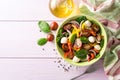 Fresh salad with spinach, bell peppers, tomatoes, red onions and mozzarella on purple wooden background. Royalty Free Stock Photo