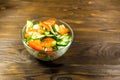 Fresh salad with tomato, cucumber, onion, parsley and dill in glass bowl on wooden table Royalty Free Stock Photo