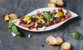 Fresh salad of tomatoes and mozzarella. Recipe with olive oil with red onion, olives and basil Royalty Free Stock Photo