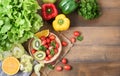 Fresh salad vegetables and fruit on wood background. Royalty Free Stock Photo