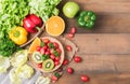 Fresh salad vegetables and fruit on wood background. Royalty Free Stock Photo