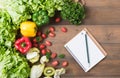 Fresh salad vegetables and fruit on wood background. Royalty Free Stock Photo