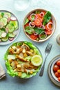 Fresh salads, overhead flat lay shot of an assortment. Caesar, tomato salad etc