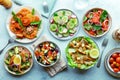 Fresh salads, overhead flat lay shot of an assortment. Variety of plates