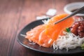 Fresh Salmom sashimi on  chopsticks with wood background Royalty Free Stock Photo