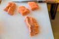 A fresh salmon on a cutting board, Japanese chef in restaurant slicing raw salmon, ingredient for seafood dish. Chef with a knife Royalty Free Stock Photo