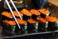 Fresh Salmon eggs sushi or ikura in japanese style in ceramic black plate on black marble table Royalty Free Stock Photo