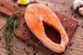 Fresh salmon fillet on a board, food close up top view. Diet, omega vitamins and seafood concept.