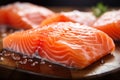 Fresh salmon fillets up close, resting on a wooden tabletop