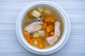 Fresh salmon fish soup with carrots, potatoes and onions in a white plate, close up. Tasty dinner consists of a fish soup with Royalty Free Stock Photo