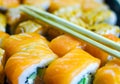 Fresh salmon philadelphia rolls. Smoked salmon rolls. Set of rolls on the board, table. One piece of roll. Food delivery, sushi. A