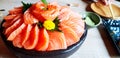 Fresh salmon sliced in black bowl or plate with wasabi on wooden table at Japanese restaurant