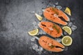 Fresh salmon steak with herbs and spices lemon rosemary on black plate background / Raw salmon fish fillet and ice for cooked Royalty Free Stock Photo