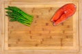 Fresh salmon steak surrounded with asparagus on a wooden cutting board Royalty Free Stock Photo