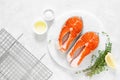 Fresh salmon steaks with ingredients for cooking on white board Royalty Free Stock Photo