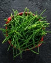 Fresh samphire in a red bowl on black background Royalty Free Stock Photo