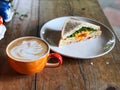 Fresh sandwich and swan shape Latte art coffee cup on the wooden table. Delicious Breakfast Royalty Free Stock Photo