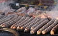 Fresh sausage and hot dogs grilled outdoors on a gas grill. Sausages on a barbecue. Fast food outside. Grilled meat. Royalty Free Stock Photo