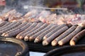 Fresh sausage and hot dogs grilled outdoors on a gas grill. Sausages on a barbecue. Fast food outside. Grilled meat. Royalty Free Stock Photo