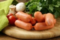 Fresh sausages and parsley on cutting board