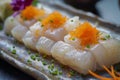 Fresh Scallop Sushi with Vibrant Fish Roe Topping on a Slate Serving Platter Garnished with Herbs and Edible Flowers Close Up Royalty Free Stock Photo