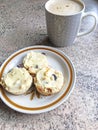 Fresh scones with butter on a plate with coffee.