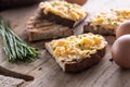 Fresh scrambled eggs spread on a slice of bread with whole eggs and fresh chive on the side Royalty Free Stock Photo