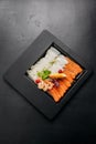 Fresh seafood platter with salmon and shrimp slices, garnished with herbs and lemon for dining