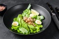 Fresh seafood salad with grilled shrimps prawns, egg, avocado and cucumber in a plate. Black background. top view Royalty Free Stock Photo