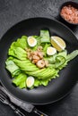 Fresh seafood salad with grilled shrimps prawns, egg, avocado and cucumber in a plate. Black background. top view Royalty Free Stock Photo